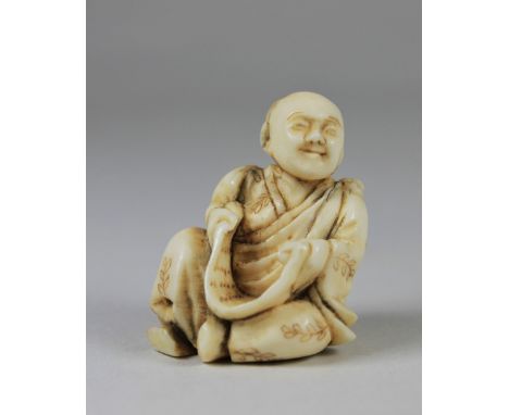 Netsuke, Japan, Elfenbein, sitzender Buddha mit Schriftrolle, am Boden Signiert. H.: 3,5 cm. Guter, altersbedingter Zustand.