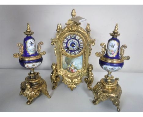A three piece continental gilt and ceramic clock garniture with enamelled dial and pendulum 