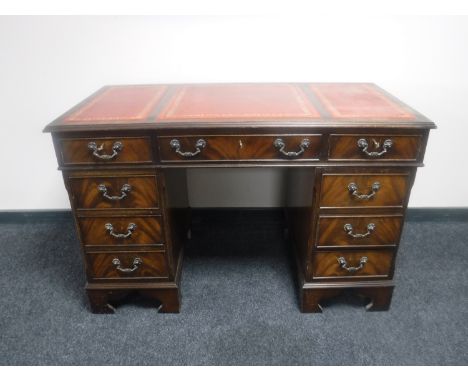 A mahogany twin pedestal writing desk with three leather tooled inset panels 