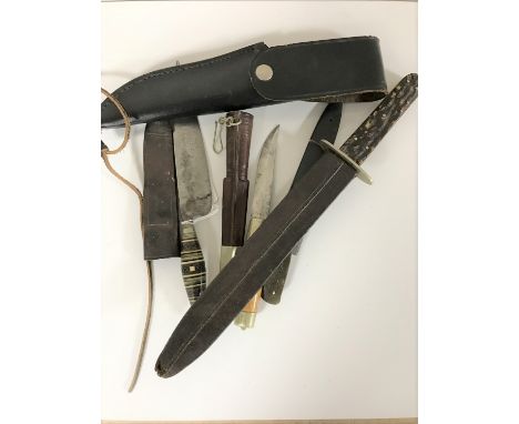 A stainless steel hunting knife in leather sheath and three further daggers 