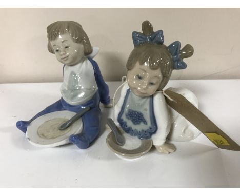 Two Nao figures of babies with plates