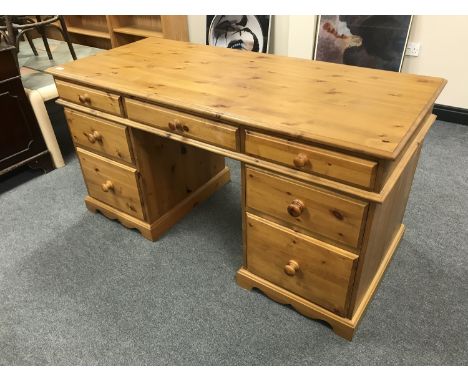 A pine twin pedestal desk fitted seven drawers