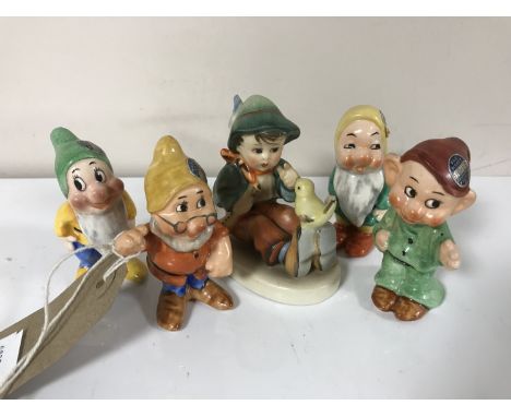 Four German Walt Disney figures; Dopey, Doc, Sleepy and Bashful, together with a Goebel figure of a buy with flute 