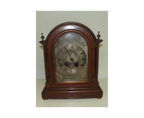 19th century bracket clock striking on a coil, silvered dial with Roman numerals flanked by two columns, brass finials and bu
