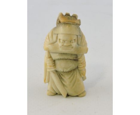 An early 20th bone netsuke, carved in the form of a warrior, H. 5cm.