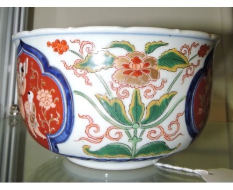 An early 20th century Chinese bowl, the foliate decoration incorporating vignettes of figures on an iron red ground, four cha