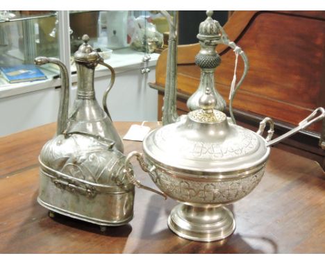 A Middle Eastern plate mounted water or wine pitcher with engraved decoration, H 43 cms, together with a similar smaller vess