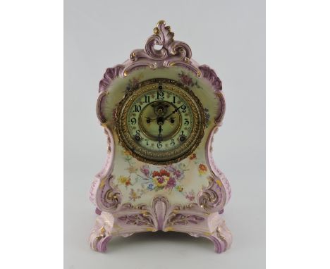 An early 20th Century Royal Bonn porcelain mantel clock the eight day ansonia movement with visible escapement within a rococ