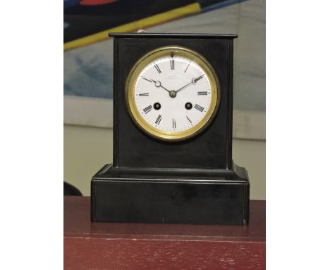 A late Victorian black slate mantel clock, with eight-day movement, the circular white enamel dial set out in Roman numerals 