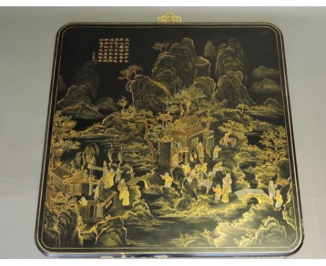 A Chinese 20th century black lacquer square panel, showing figures in a temple in a mountainous landscape, characters to the 