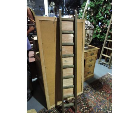 A tall picture frame modelled as a vintage ladder with seven glazed apertures, H. 144cm.