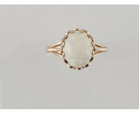 A white opal dress ring, the oval cabouchon cut stone claw set in a yellow metal band stamped 9ct, 2.3g.