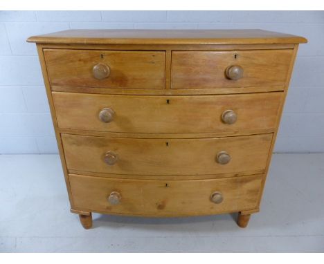 Bow fronted pine chest of drawers on turned feet with three large drawers and two over