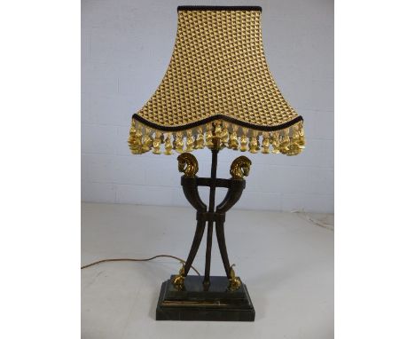 Three-stemmed occasional lamp with brass horse head finials and brass hoofed feet on marble plinth with black and gold geomet