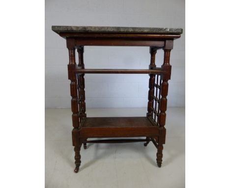 Marble topped three tier table with fretwork to sides and ceramic castors