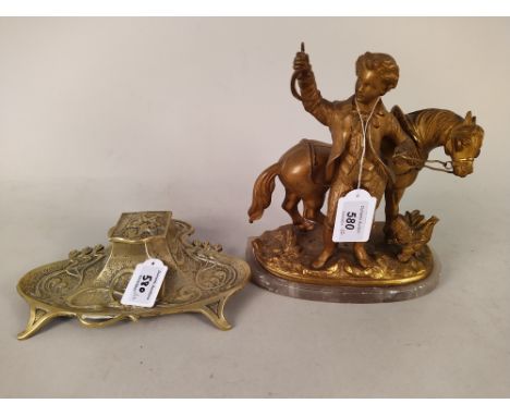 An Art Nouveau brass ink stand with ceramic well, 22cm wide plus a gold painted spelter boy with horse figurine, 21cm high