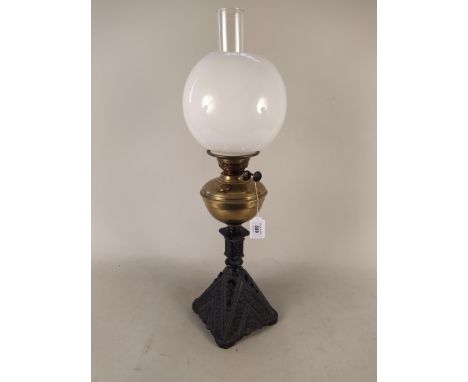 A duplex oil lamp with brass reserve, spelter base, shade and funnel, 67cm tall