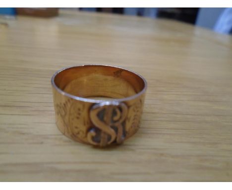 A yellow metal rose coloured band ring with SR monogram flanked by floral decoration, unmarked tests as 14k, weight 6.4gLocat