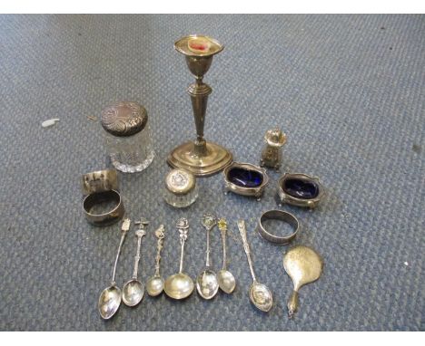 A collection of silver to include a filled candlestick, pepper pot, two salts, napkin ring, miniature hand mirror, two silver