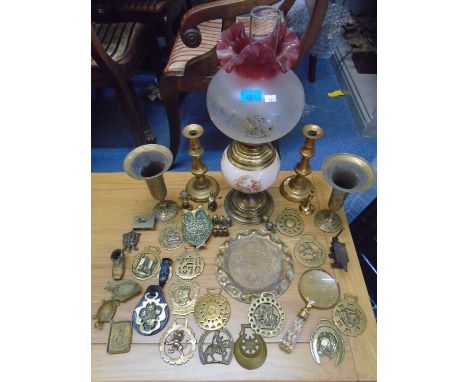A porcelain and brass oil lamp with frosted and etched glass shade, and a quantity of brass ware to include horse brassesLoca