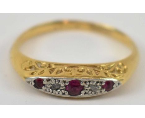 A yellow metal and platinum three stone ruby and diamond ring, size L/M, 2.1g.