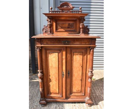 A late 19th century Continental walnut cabinet with shelf above frieze drawer and panel door flanked by turned fluted columns