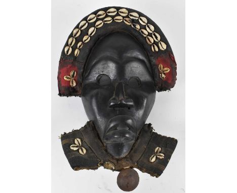 TRIBAL ART; a carved Dan mask adorned with cowrie shells, height 37cm.