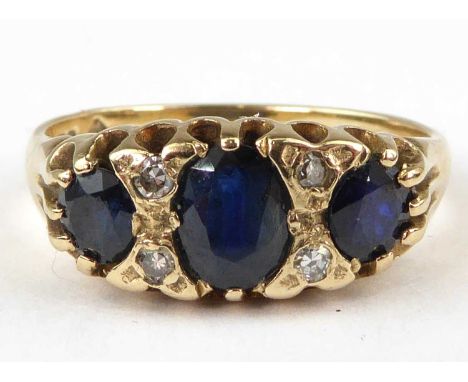 A 9ct gold sapphire and diamond ring, three oval cut sapphires separated by two rows of two tiny diamonds, size L, approx. 2.