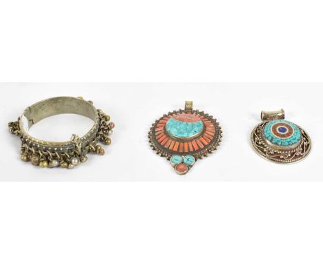 Two Eastern white metal pendants set with semi-precious stones, also a bangle (3).