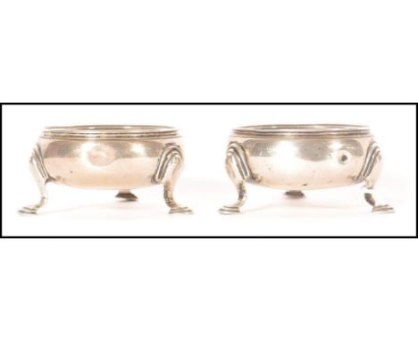 A pair of mid 18th century George II Georgian silver hallmarked table salts of circular form raised on tripod stepped feet. H