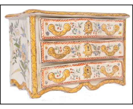 A 19th century Faience handpainted serpentine fronted commode chest of drawers jewellery box having 3 drawers that open, Puce