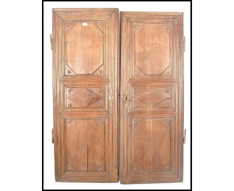 A pair of 18th century French chestnut / oak armoire panel doors. Each with fielded carved panels, large cast iron hingework 