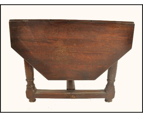 An 18th century country oak hexagonal drop leaf gate leg dining table. Raised on gun barrel thick turned legs with stretchers