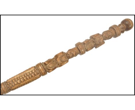 An early 20th century carved hardwood walking stick cane of Polynesian origin. Hand carved with figures bearing harvest gifts