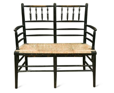 Attributed to Morris & Co., an ebonised wood two-seat settle,  the rush seat below a bobbin-turned back raised on tapering cy