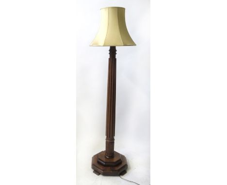 A 20th Century mahogany standard lamp
The ribbed stem raised on a stepped octagonal base, fitted with a beige fabric shade, h