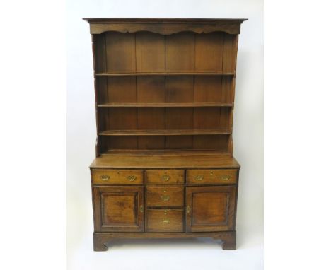 A 19th Century oak dresser 
The three shelf top over a base with five drawers and two doors, raised on bracket feet, height 2