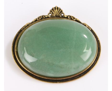 Jade brooch, the oval stone housed in a gilt setting with shell form pediment