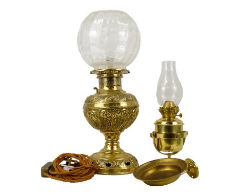 An early 20th century brass oil lamp - with foliate repousse reservoir and etched glass globe, height 46cm, together with a g