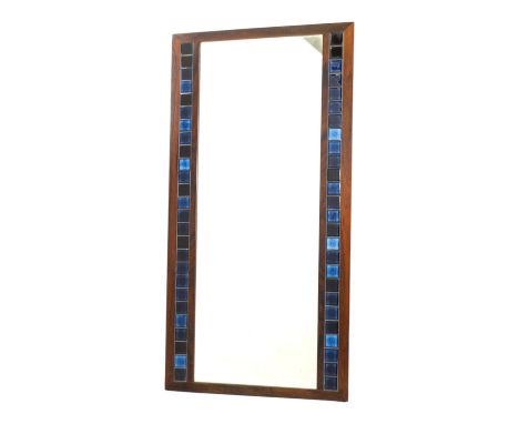 A vintage Danish wall mirror - the rosewood frame inset with two rows of blue tiles, 116cm high