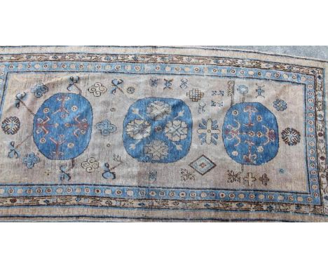 A 19thC Middle Eastern carpet runner, in a floral geometric pattern on brown ground, predominantly in blue and red, 101cm x 2