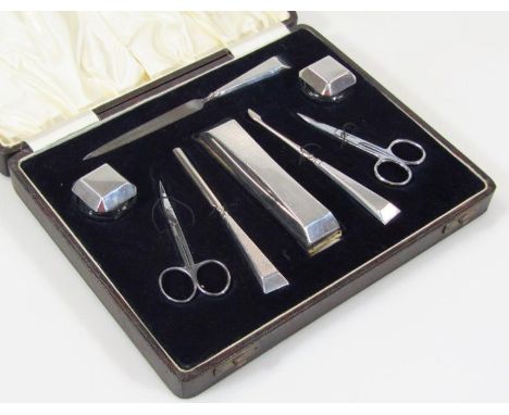 A cased George VI silver part engine turned travel set, to include file, 17cm wide, nail scissors, lidded jars, etc., in fitt