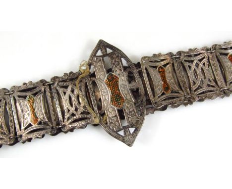 A silver plated belt, of elaborate design, set with pierced part enamel sections with large buckle centre, 67cm long.