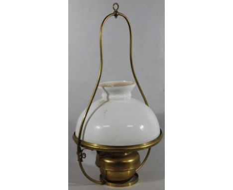 An early 20thC brass hanging lamp, with milk glass shade, metal surround with metal burner and ring top, 65cm high