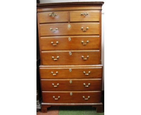 A George III mahogany tall boy chest or chest, with an overhanging dentil top raised above two short and three long drawers t