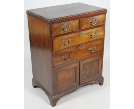 A late 19thC/early 20thC mahogany compactum chest, with a heavily carved frieze top above two short and two long cockbeaded d