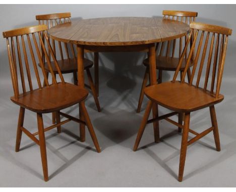 A retro melamine style walnut finish dining room suite, comprising drop leaf table and four stick back chairs with shaped sea