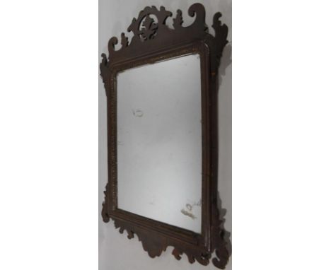 A late 19thC mahogany framed Chippendale style fret mirror, with a pierced floral mount, shaped glass, moulded outline and ca