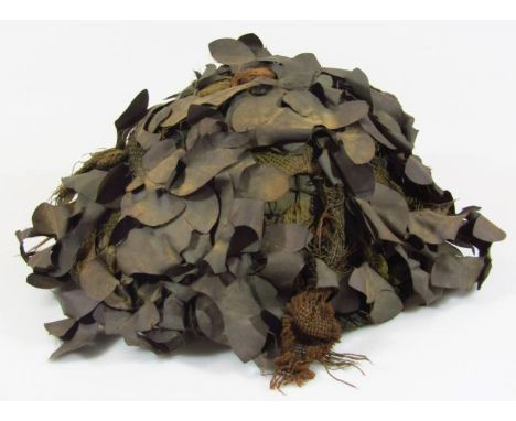 A khaki Army camouflage war helmet, of circular outline with mock leaves, 29cm wide.  