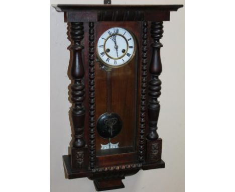 A late 19thC stained mahogany and pine Black Forest wall clock, the enamel 15cm dia. dial revealing a key wind pendulum swung